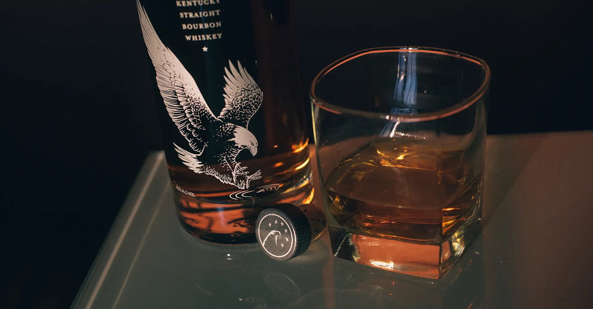 Eagle Rare bourbon bottle beside a rocks glass of bourbon